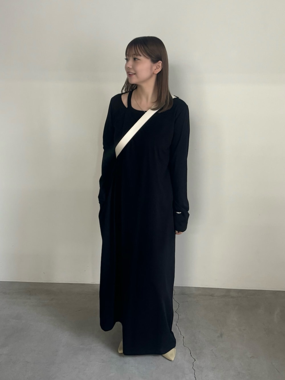 ブラック系のワンピース、ホワイト系のショルダーバッグ、ベージュ系のサンダルを着用したレディースの夏コーディネートの2枚目の写真