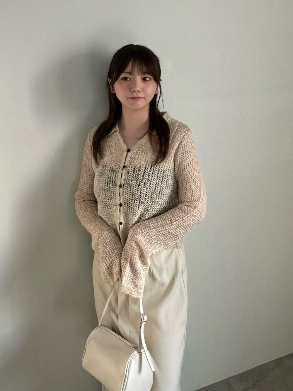 ベージュ系のカーディガン/ボレロ、ブラック系のキャミソール、ホワイト系のスカートを着用したレディースの春コーディネートの3枚目の写真