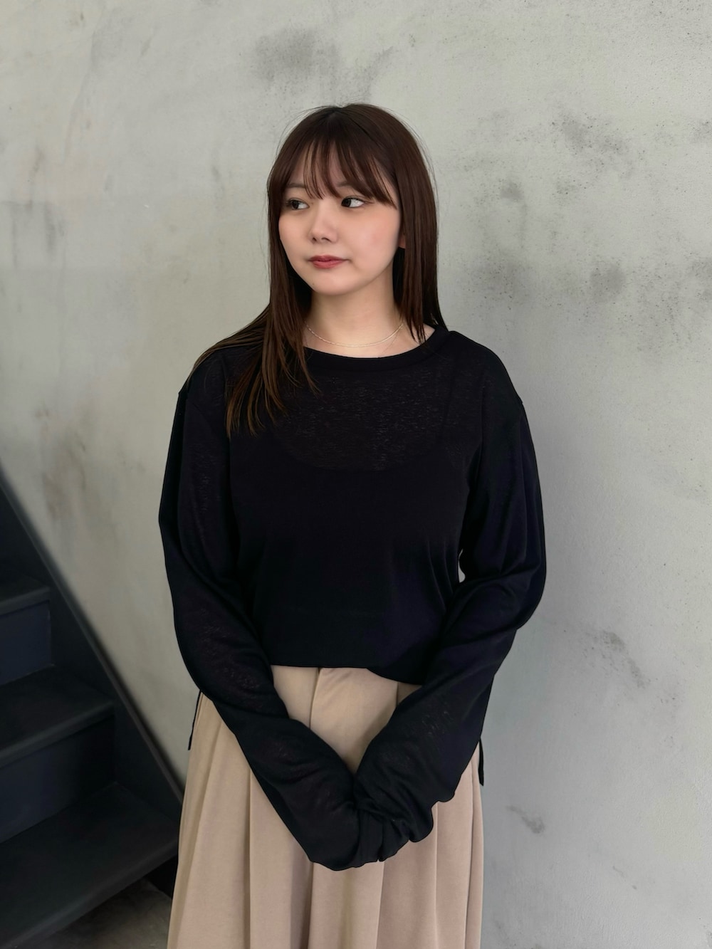 ブラック系のTシャツ/カットソー、ベージュ系のスラックスを着用したレディースの冬コーディネートの4枚目の写真