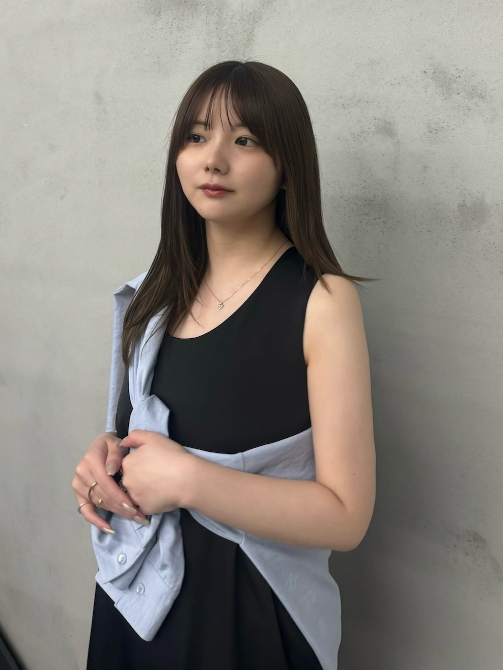 ブラック系のワンピース、ブラック系のその他パンツ、ブルー系のシャツ/ブラウスを着用したレディースの春コーディネートの3枚目の写真