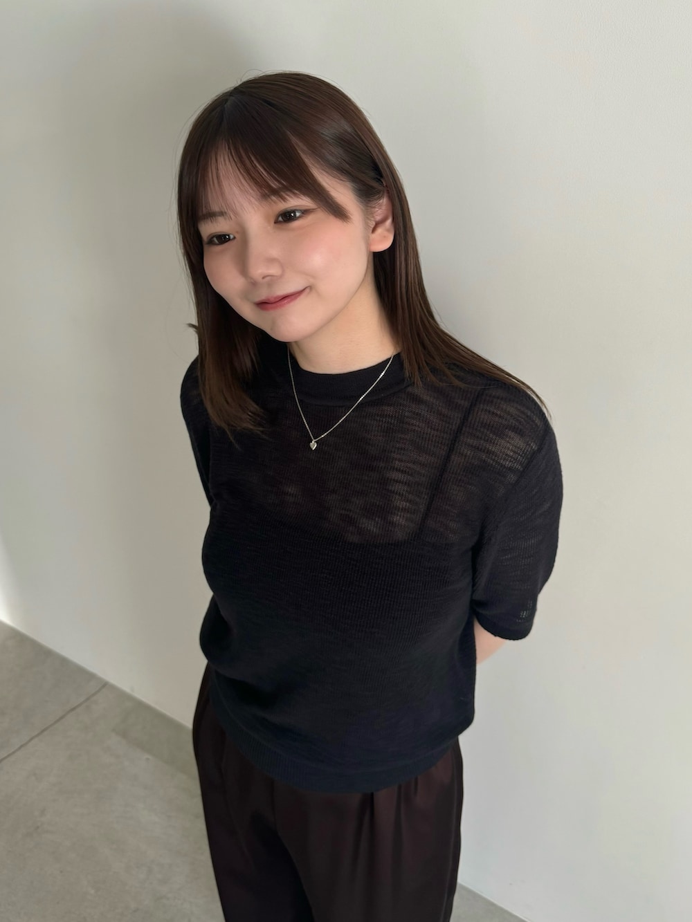 ブラック系のニット/セーター、ブラック系のキャミソール、ブラウン系のその他パンツを着用したレディースの春コーディネートの6枚目の写真