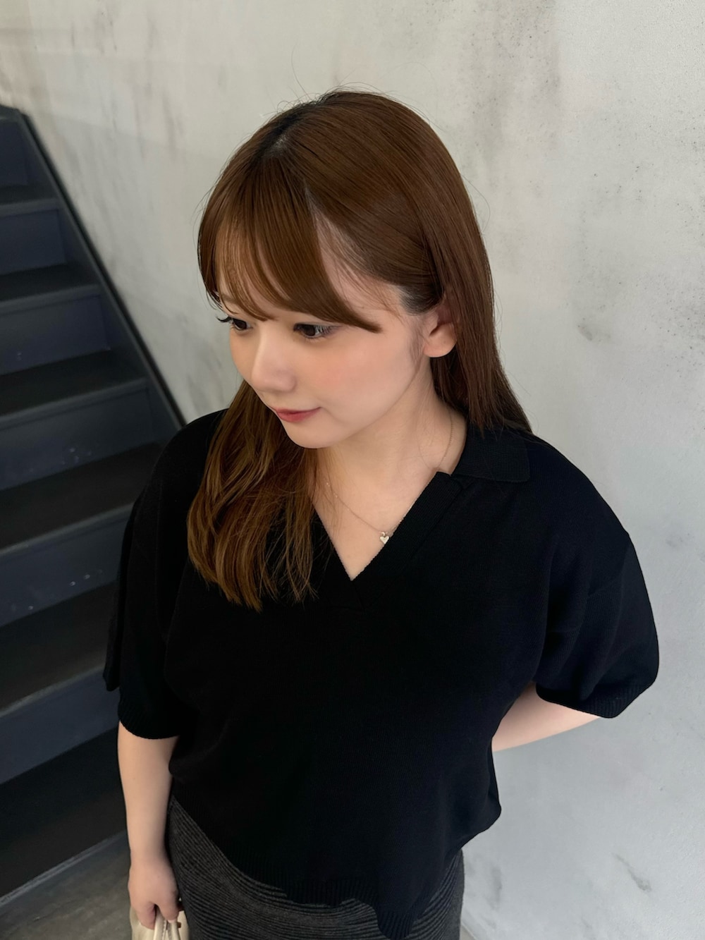 ブラック系のニット/セーター、ブラック系のスカート、ベージュ系のボストンバッグを着用したレディースの夏コーディネートの4枚目の写真
