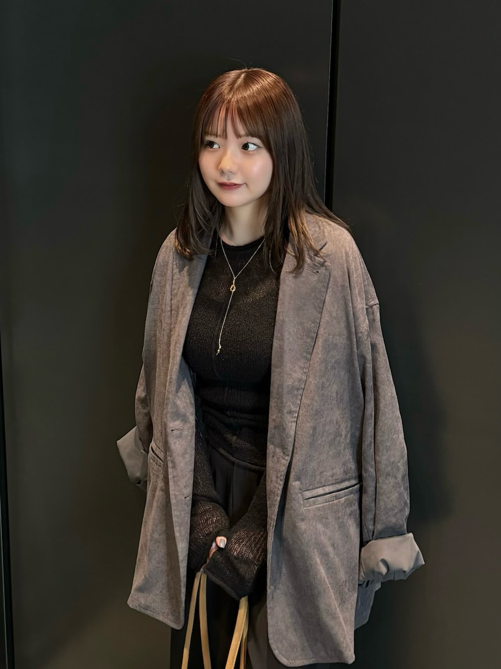 ブラック系のニット/セーター、ブラック系のキャミソール、グレー系のテーラードジャケットを着用したレディースの夏コーディネートの5枚目の写真