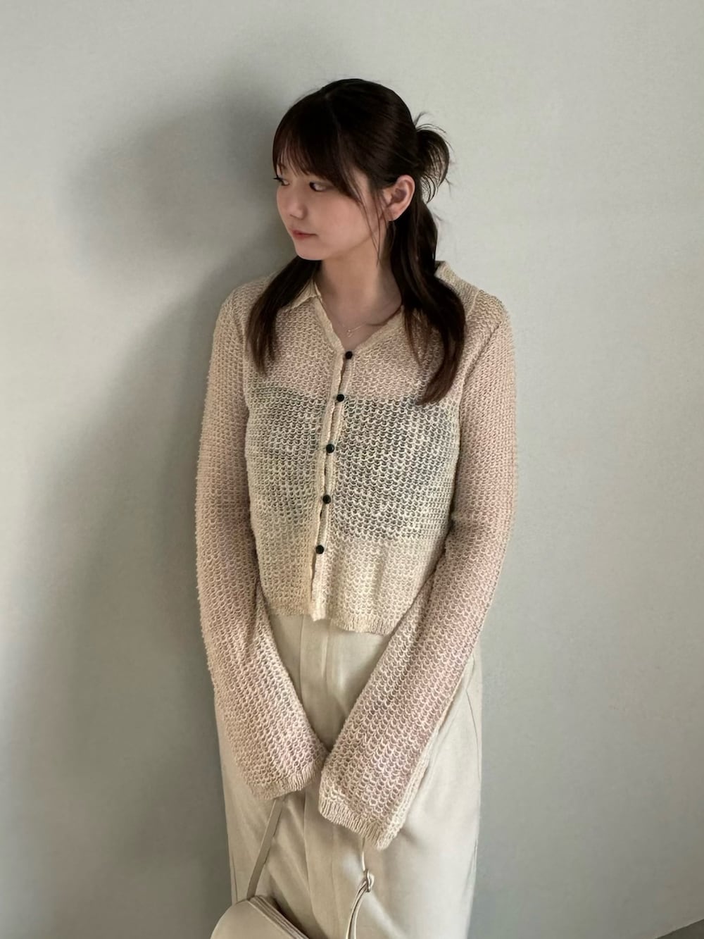 ベージュ系のカーディガン/ボレロ、ブラック系のキャミソール、ホワイト系のスカートを着用したレディースの春コーディネートの4枚目の写真