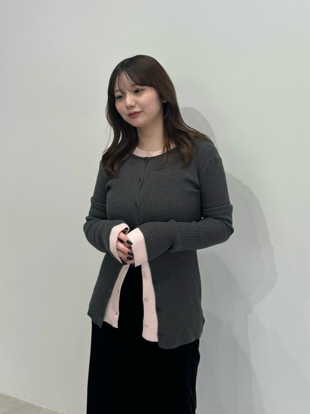 グレー系のカーディガン/ボレロ、ピンク系のカーディガン/ボレロ、ブラック系のスカートを着用したレディースの冬コーディネートの3枚目の写真