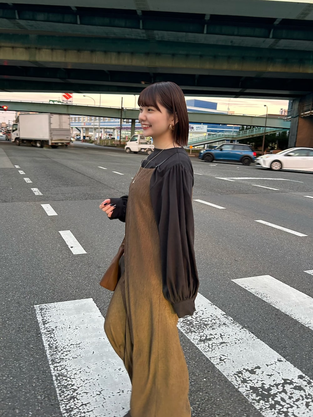 ブラウン系のハンドバッグ、グリーン系のワンピース、ブラック系のシャツ/ブラウスを着用したレディースの夏コーディネートの3枚目の写真