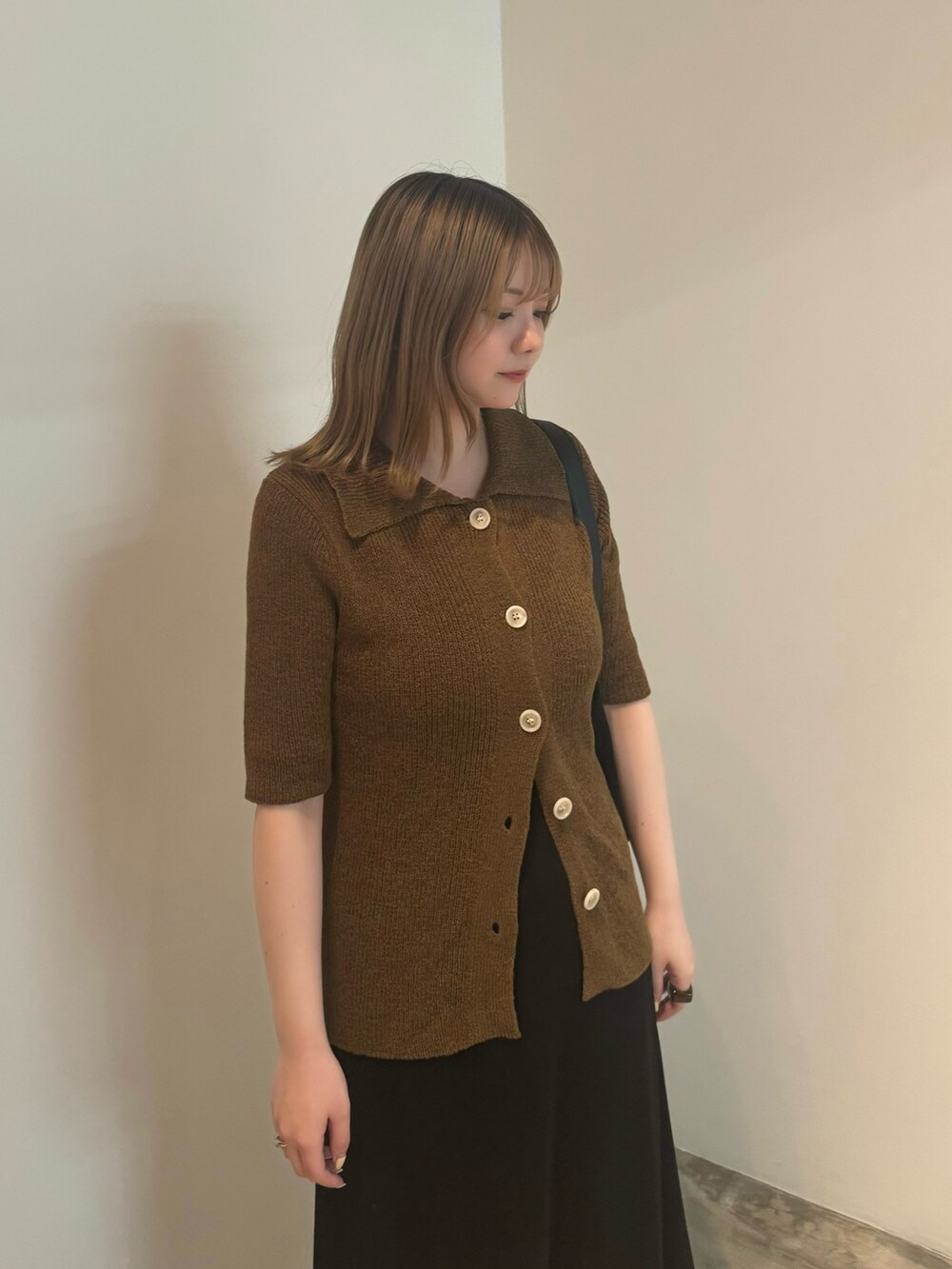 グリーン系のカーディガン/ボレロ、ホワイト系のキャミソール、ブラック系のスカートを着用したレディースの夏コーディネートの4枚目の写真