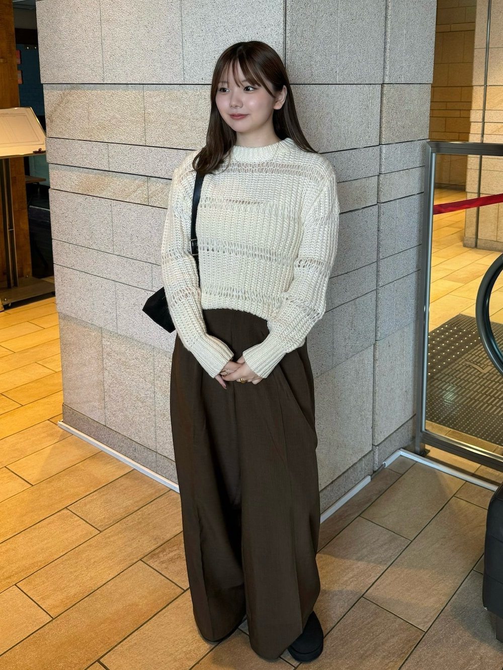 ホワイト系のニット/セーター、ホワイト系のキャミソール、ブラウン系のスラックスを着用したレディースの秋コーディネートの4枚目の写真