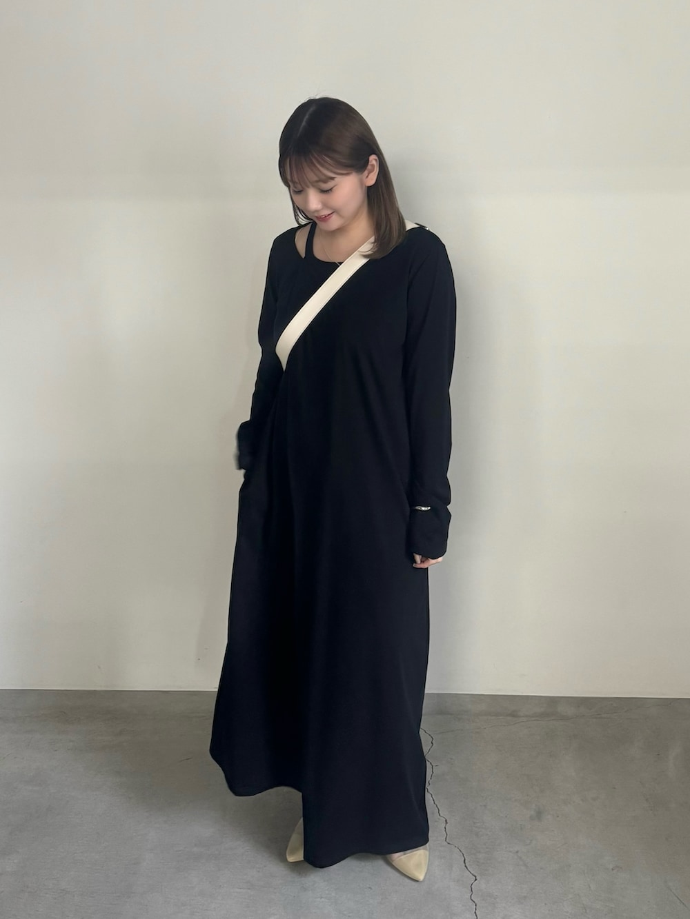 ブラック系のワンピース、ホワイト系のショルダーバッグ、ベージュ系のサンダルを着用したレディースの夏コーディネートの3枚目の写真