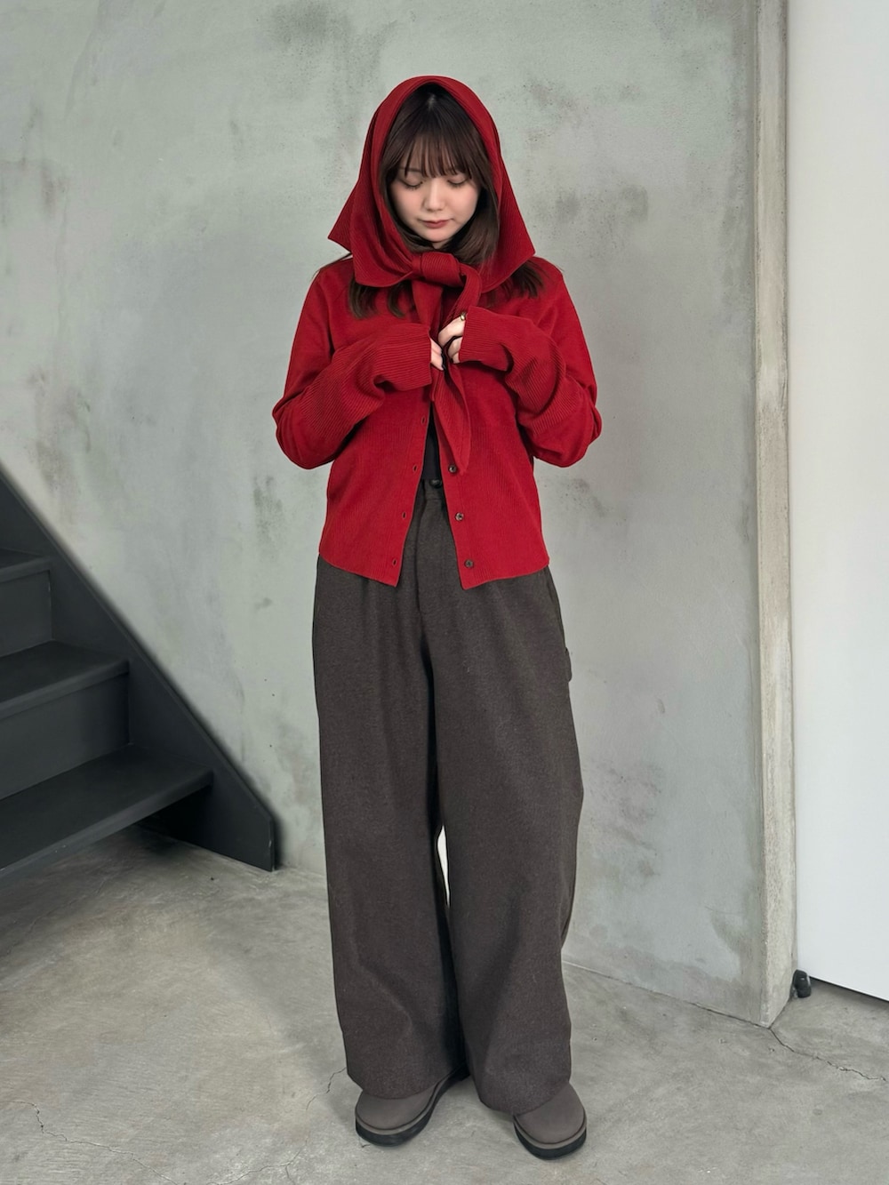 レッド系のニット/セーター、ブラウン系のその他パンツ、グレー系のスリッポンを着用したレディースの冬コーディネートの3枚目の写真