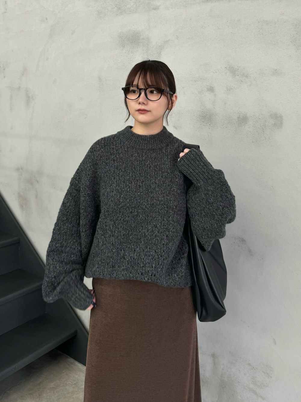 グレー系のニット/セーター、ブラウン系のスカート、ブラック系のスリッポンを着用したレディースの冬コーディネートの5枚目の写真