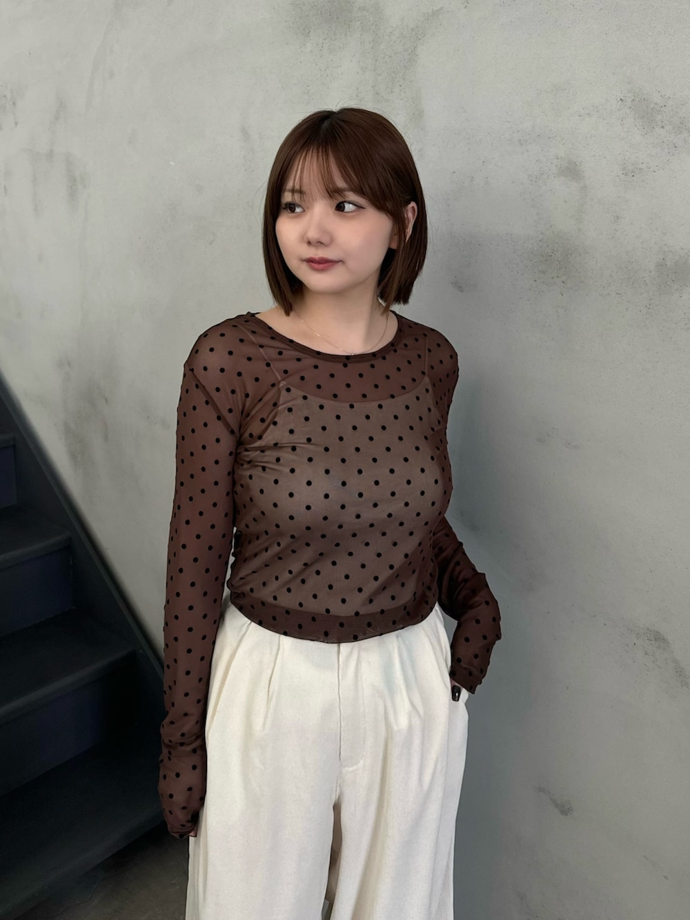 ブラウン系のTシャツ/カットソー、ベージュ系のキャミソール、ホワイト系のスラックスを着用したレディースの秋コーディネートの4枚目の写真