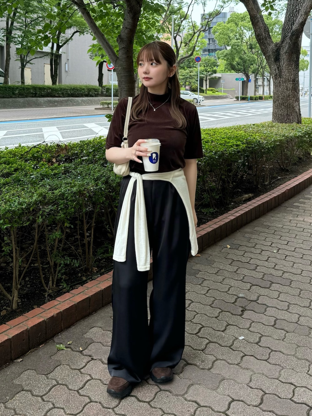 ブラウン系のTシャツ/カットソー、ホワイト系のハンドバッグ、ベージュ系のTシャツ/カットソーを着用したレディースの夏コーディネートの2枚目の写真