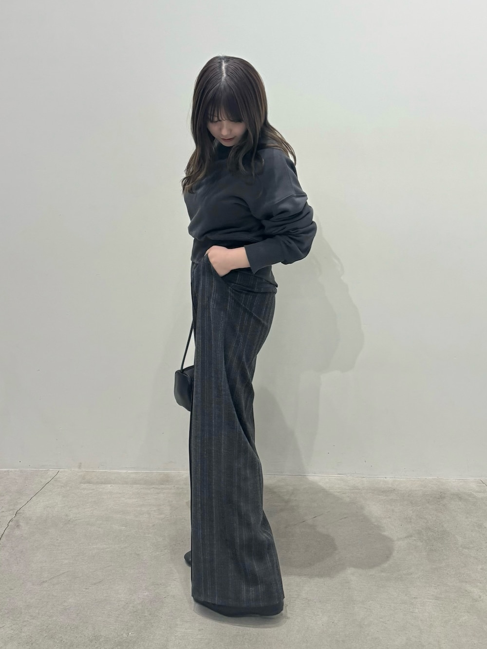 ブラック系のスウェット、ブラック系のスラックスを着用したレディースの冬コーディネートの2枚目の写真