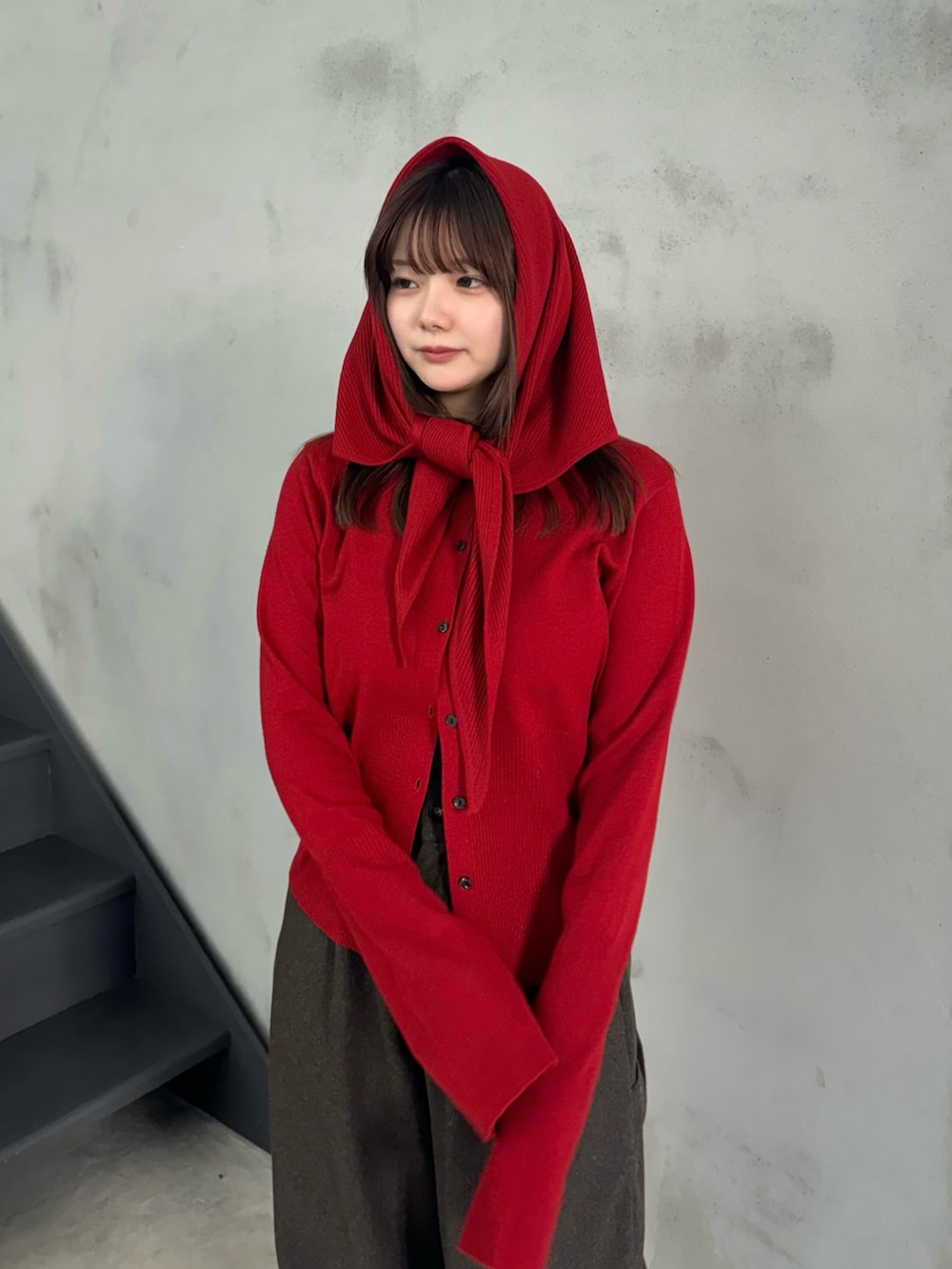 レッド系のニット/セーター、ブラウン系のその他パンツ、グレー系のスリッポンを着用したレディースの冬コーディネートの4枚目の写真