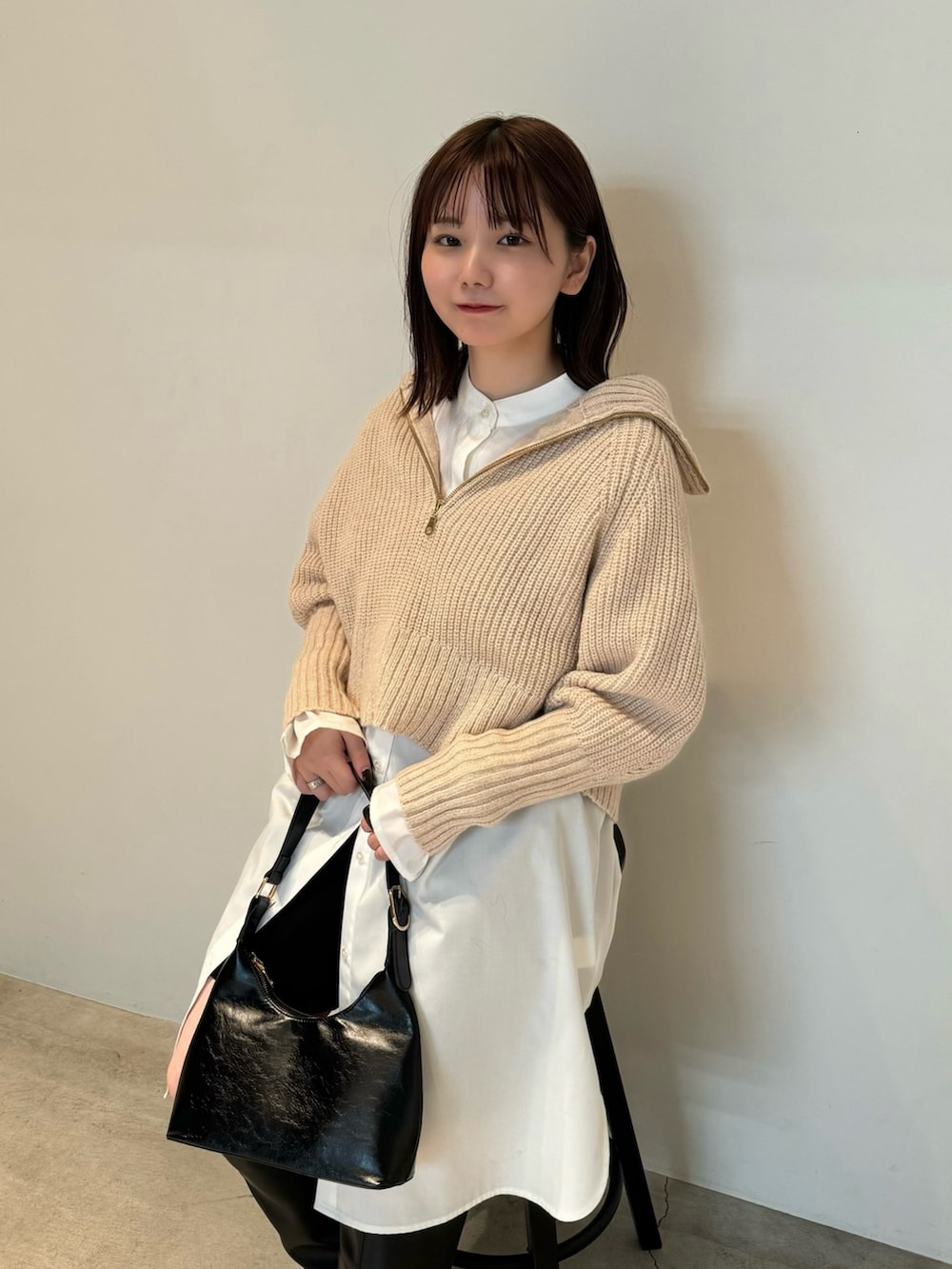 ベージュ系のニット/セーター、ホワイト系のシャツ/ブラウス、ブラック系のその他パンツを着用したレディースの秋コーディネートの3枚目の写真