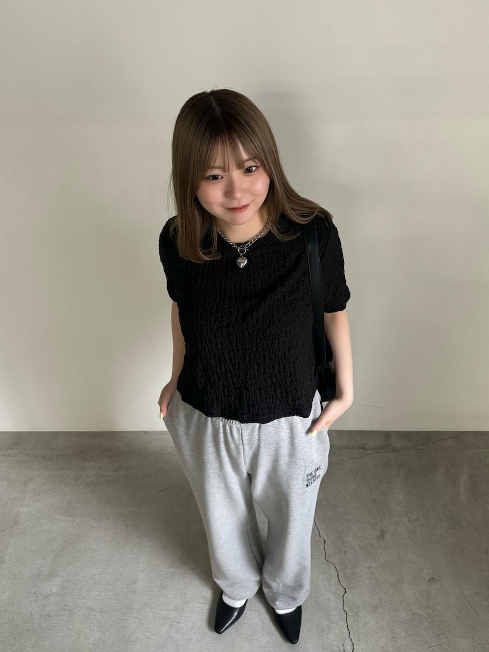 ブラック系のTシャツ/カットソー、グレー系のスウェットパンツ、ブラック系のサンダルを着用したレディースの夏コーディネートの4枚目の写真