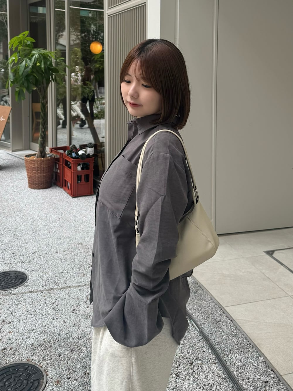 グレー系のシャツ/ブラウス、ベージュ系のスウェットパンツ、ホワイト系のハンドバッグを着用したレディースの秋コーディネートの5枚目の写真