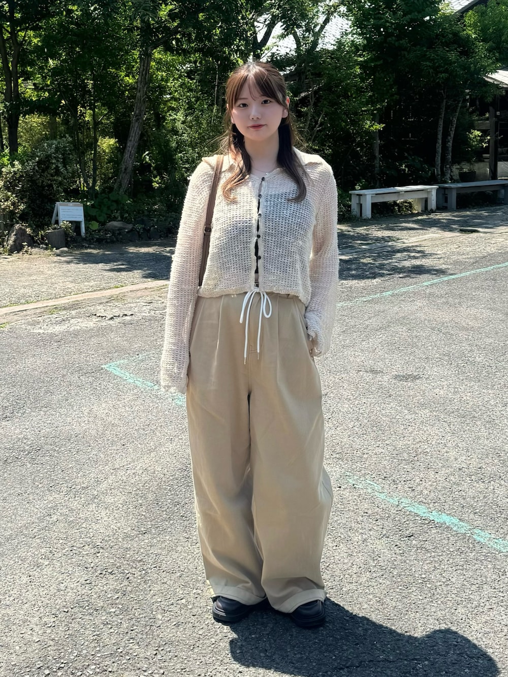 ベージュ系のカーディガン/ボレロ、ブラック系のキャミソール、イエロー系のハンドバッグを着用したレディースの春コーディネートの2枚目の写真