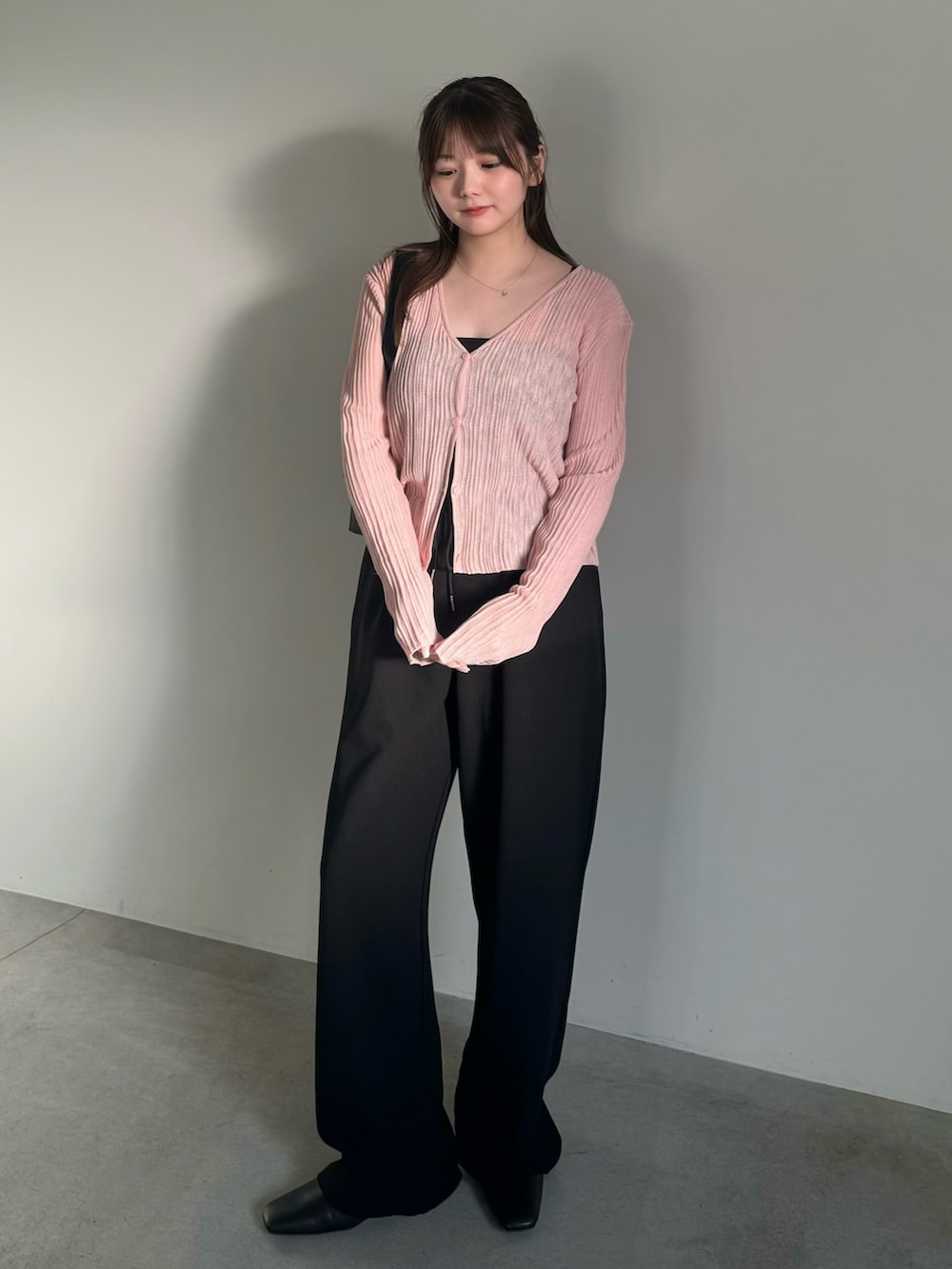 ブラック系のその他パンツ、ブラック系のスリッポン、ピンク系のカーディガン/ボレロを着用したレディースの春コーディネートの2枚目の写真