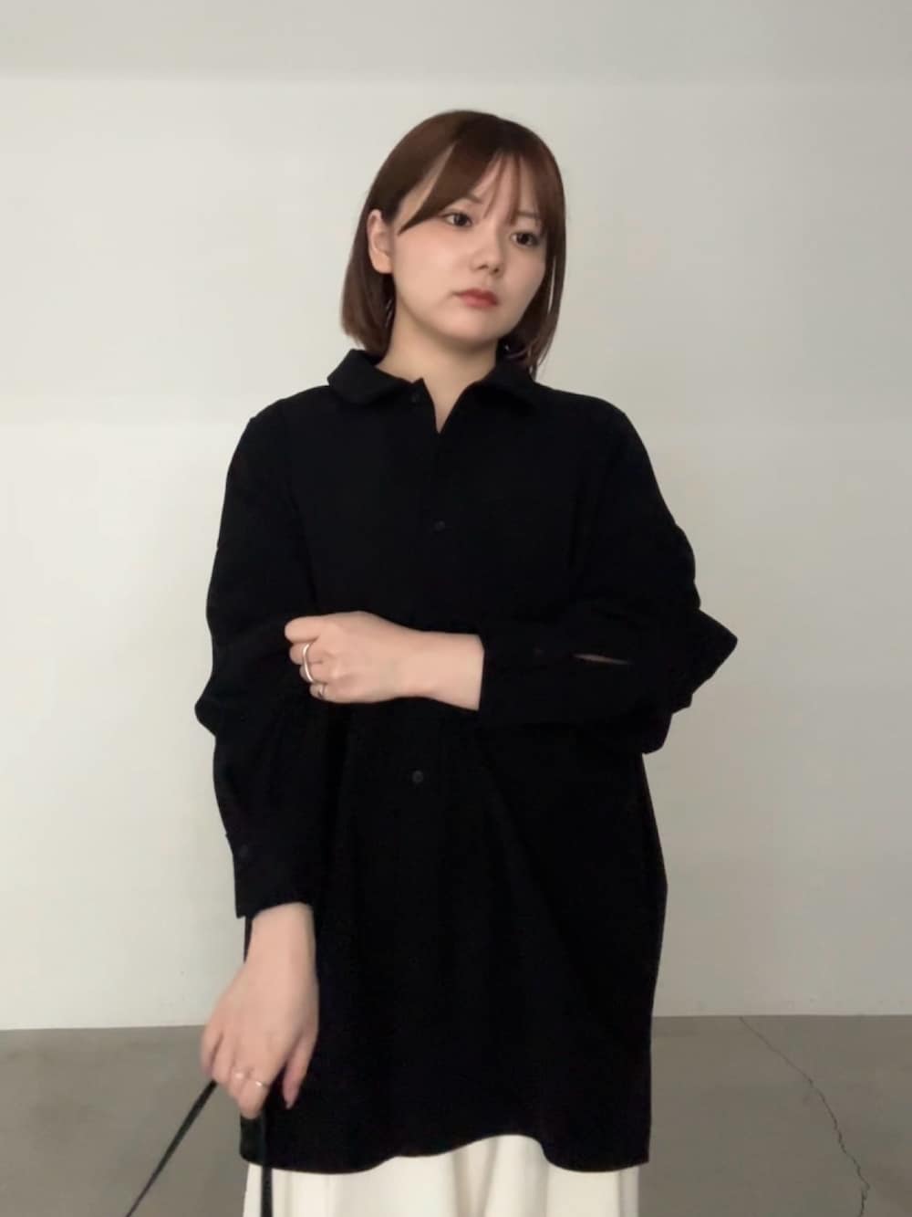 ブラック系のシャツ/ブラウス、ベージュ系のスラックス、ブラック系のハンドバッグを着用したレディースの秋コーディネートの3枚目の写真