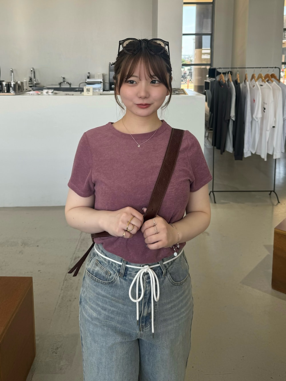 ブラウン系のショルダーバッグ、パープル系のTシャツ/カットソー、ブラウン系のサングラスを着用したレディースの夏コーディネートの4枚目の写真