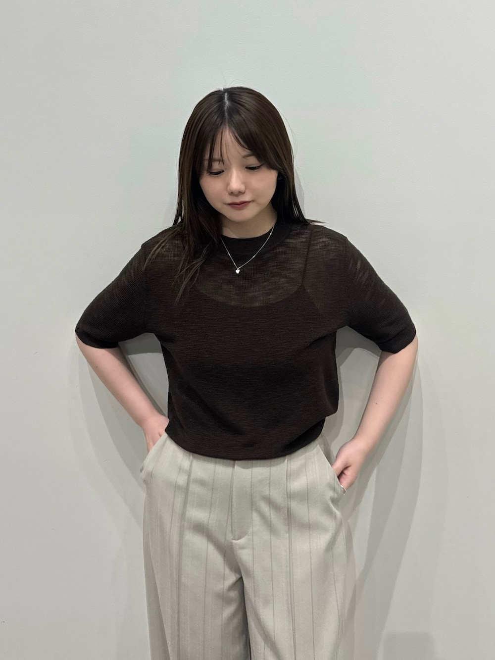 ブラウン系のニット/セーター、グレー系のスラックス、ブラック系のスリッポンを着用したレディースの春コーディネートの5枚目の写真