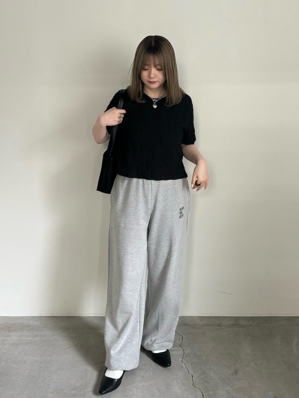 ブラック系のTシャツ/カットソー、グレー系のスウェットパンツ、ブラック系のサンダルを着用したレディースの夏コーディネートの3枚目の写真
