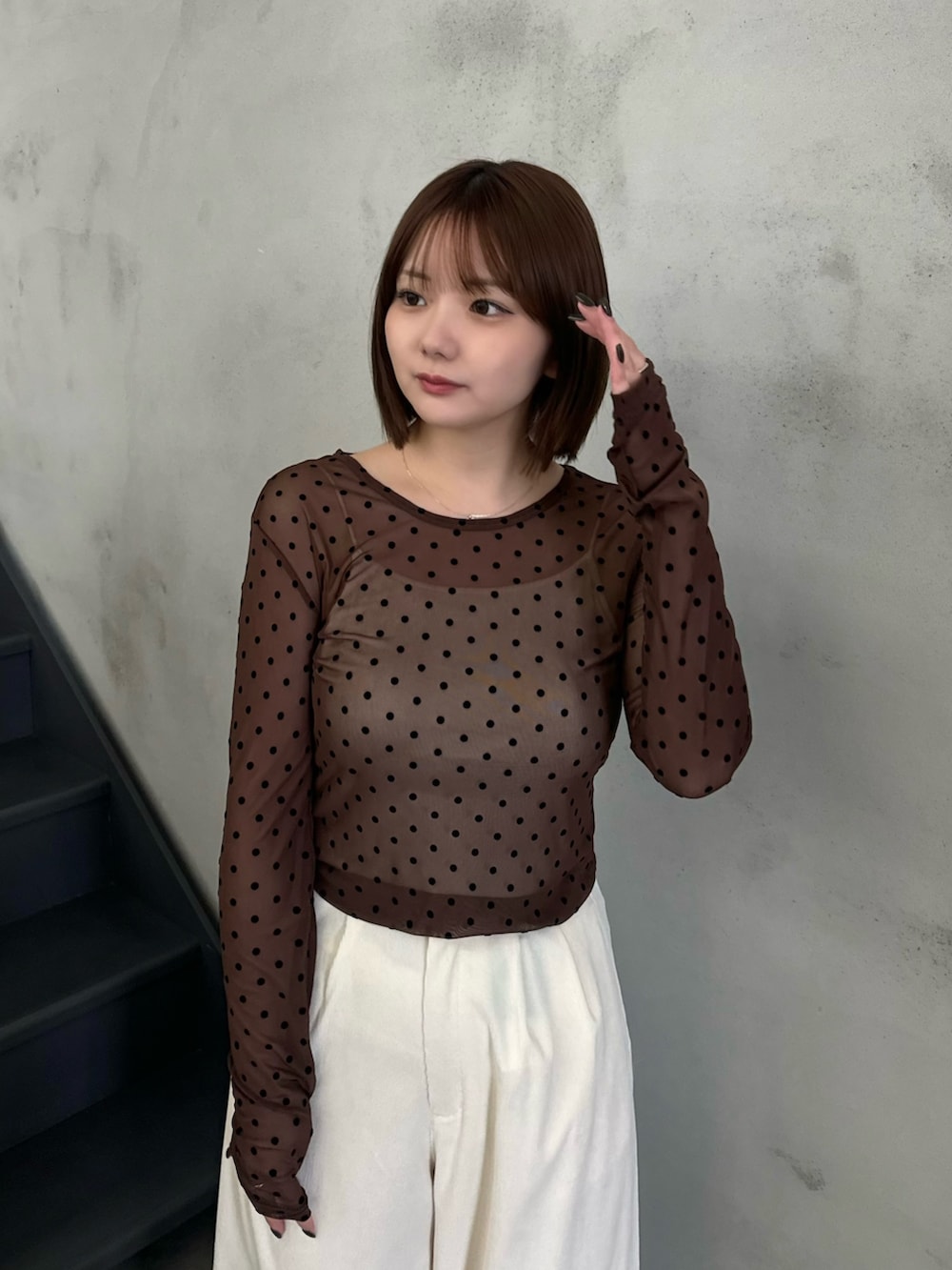 ブラウン系のTシャツ/カットソー、ベージュ系のキャミソール、ホワイト系のスラックスを着用したレディースの秋コーディネートの3枚目の写真