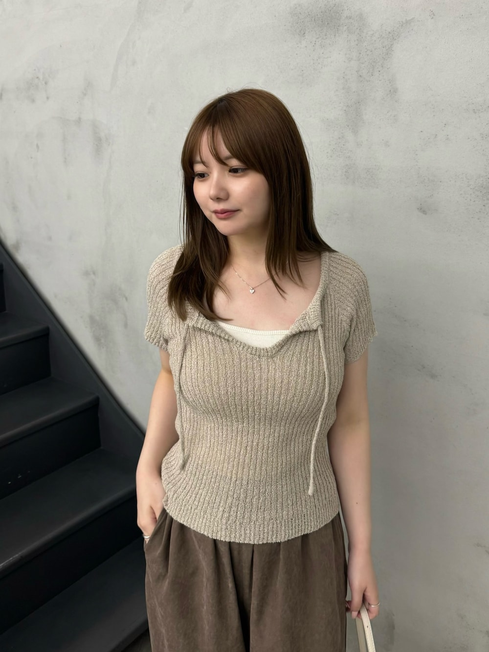 ホワイト系のキャミソール、ベージュ系のニット/セーター、ブラウン系のその他パンツを着用したレディースの夏コーディネートの3枚目の写真