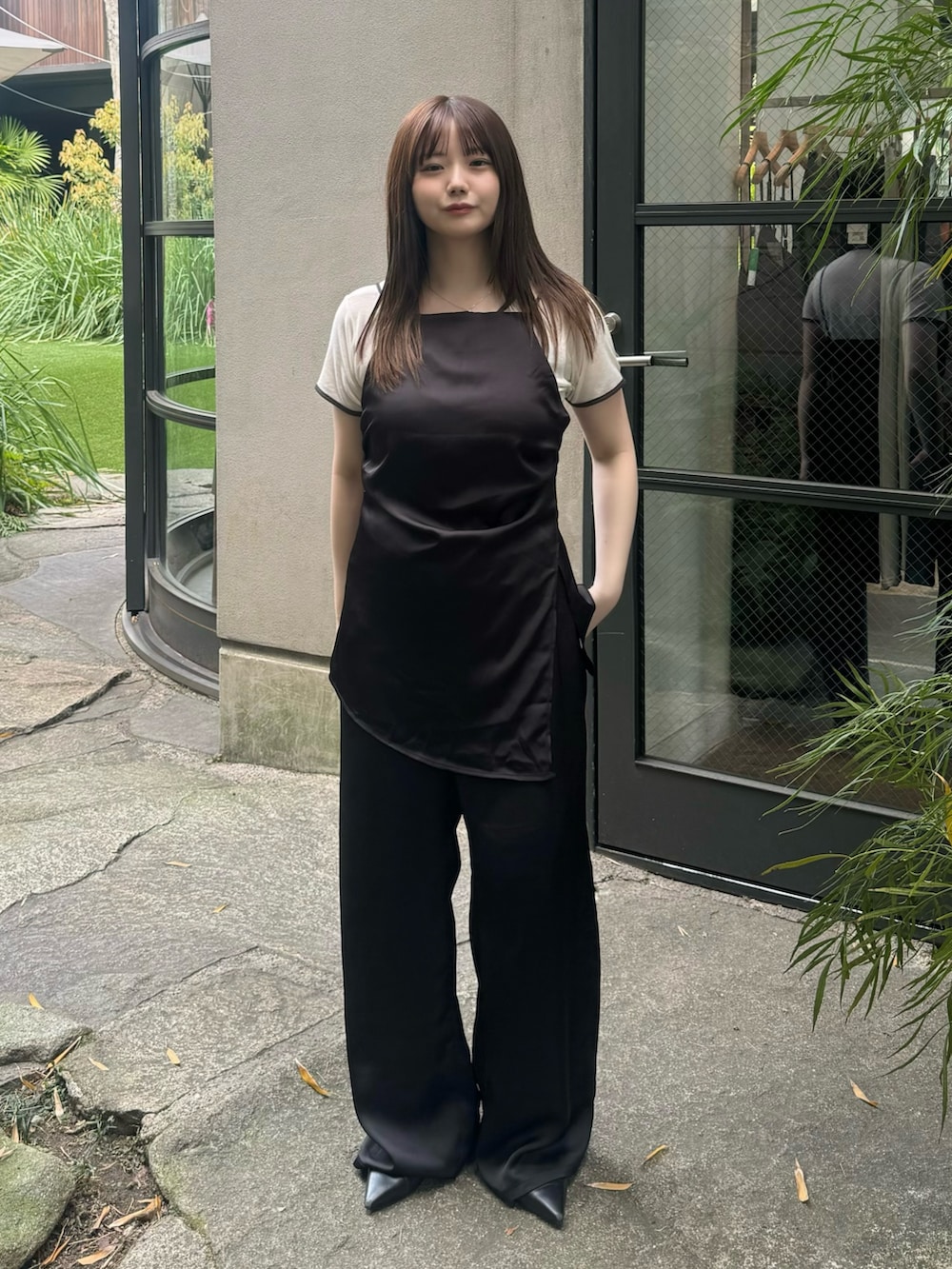 ブラック系のその他パンツ、ブラック系のキャミソール、ベージュ系のTシャツ/カットソーを着用したレディースの春コーディネートの2枚目の写真