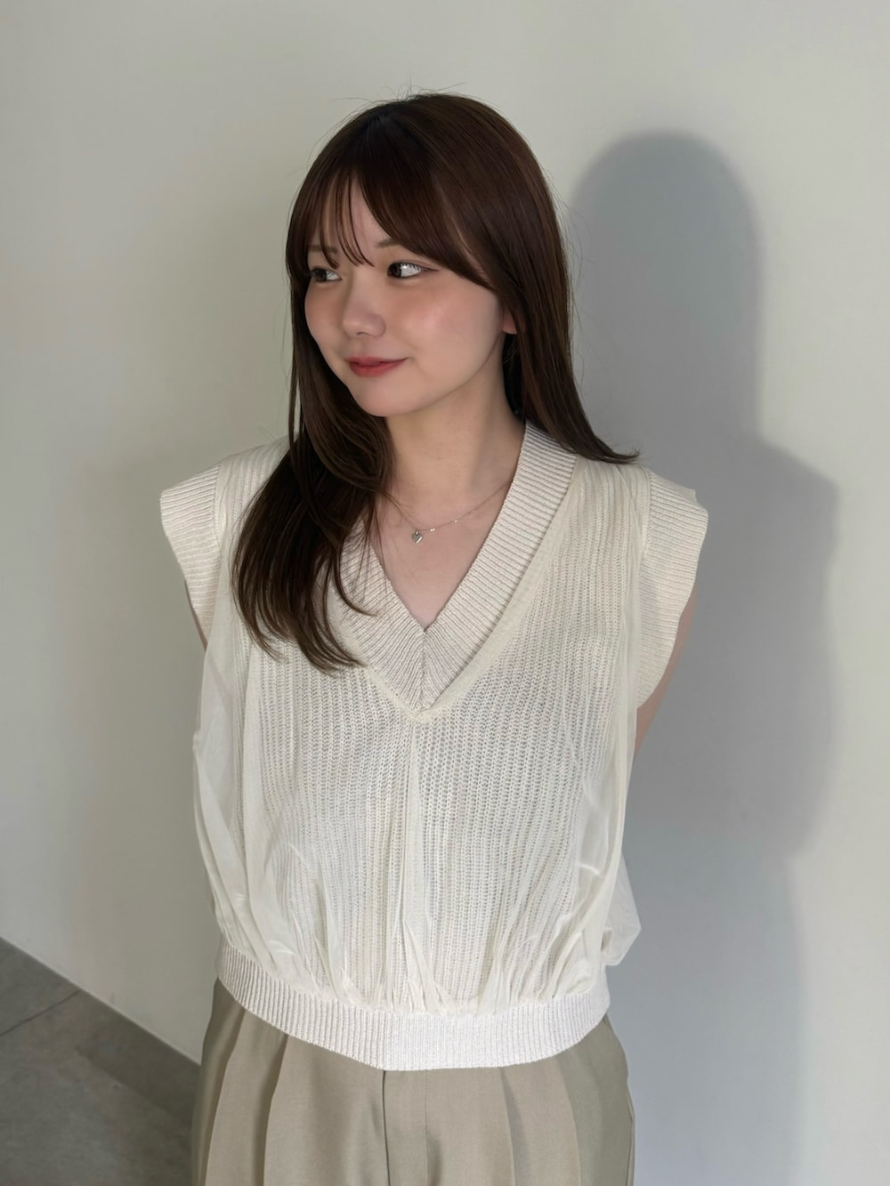 ベージュ系のベスト、ブラック系のキャミソール、ベージュ系のスラックスを着用したレディースの夏コーディネートの5枚目の写真