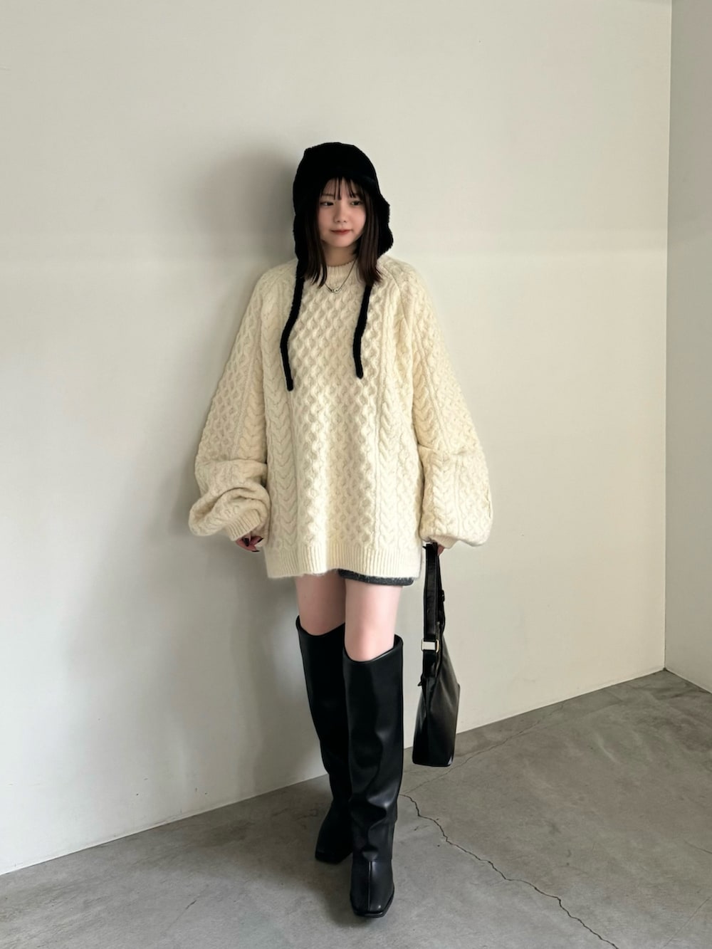 ホワイト系のニット/セーター、グレー系のその他パンツ、ブラック系のハンドバッグを着用したレディースの秋コーディネートの2枚目の写真