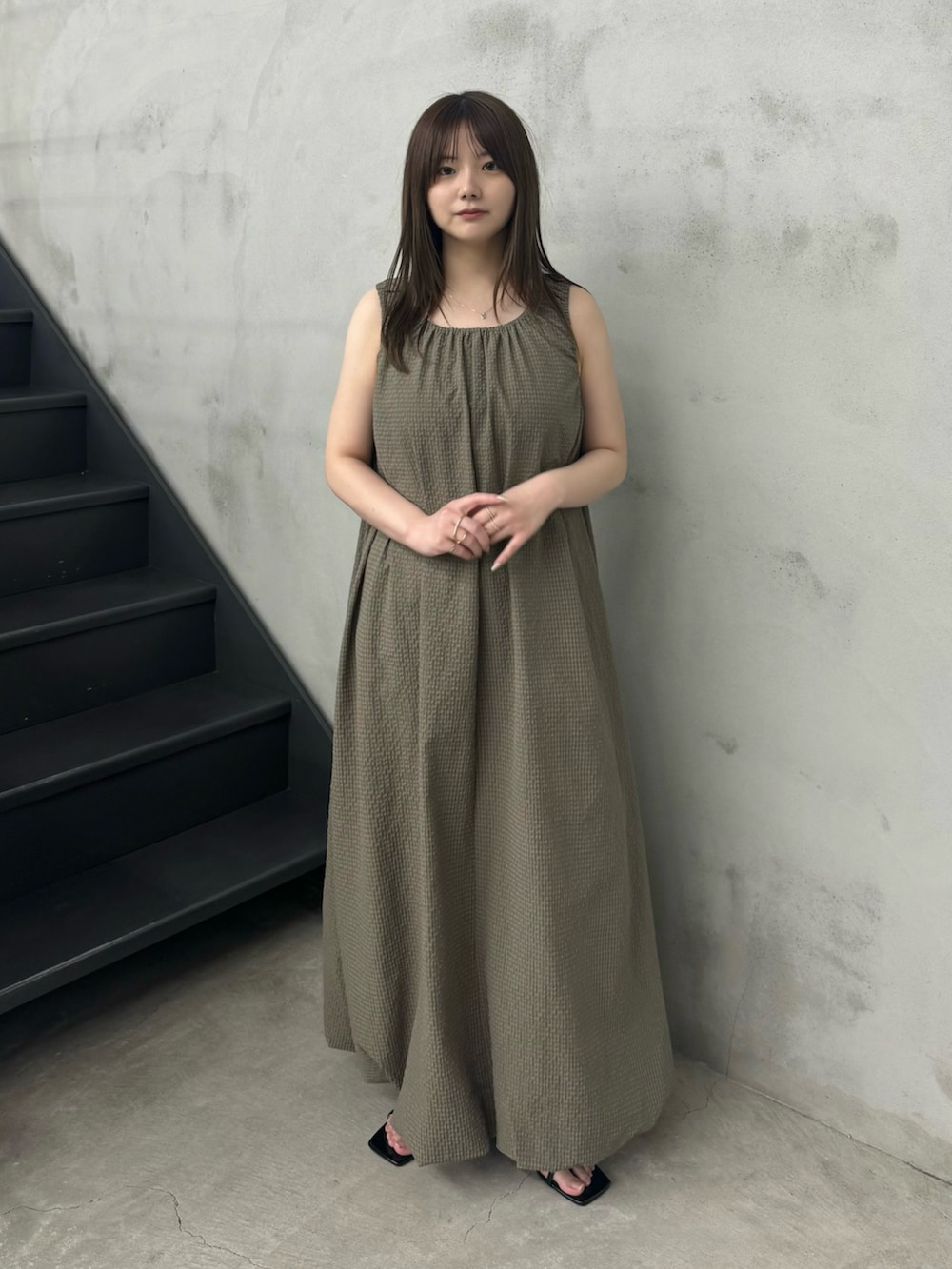 ベージュ系のワンピース、ブラック系のサンダルを着用したレディースの春コーディネートの2枚目の写真