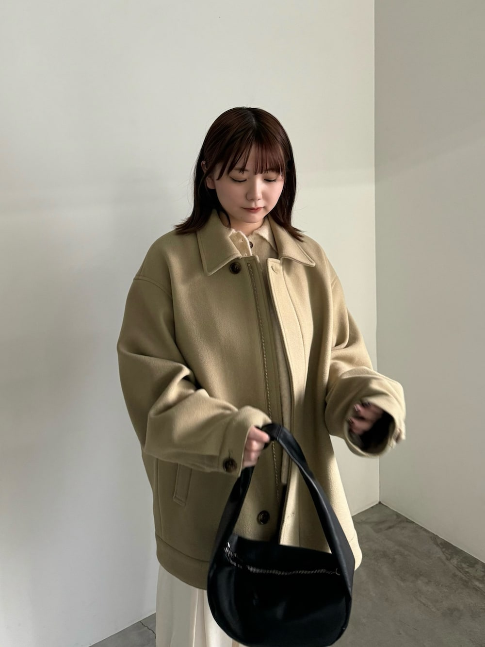 ベージュ系のカーディガン/ボレロ、ブラック系のショルダーバッグ、ベージュ系のその他アウターを着用したレディースの冬コーディネートの4枚目の写真