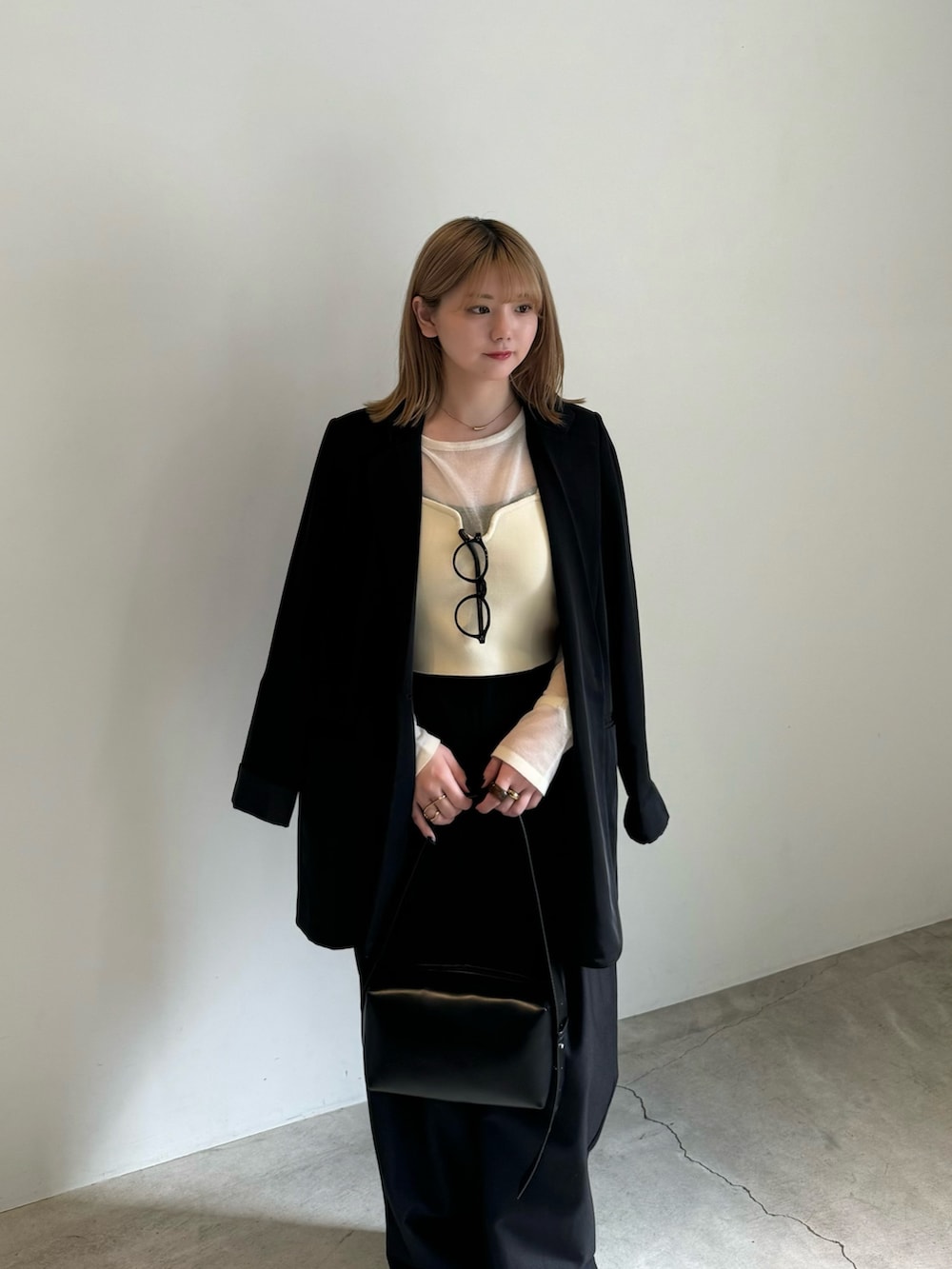 ブラック系のテーラードジャケット、ホワイト系のニット/セーター、ホワイト系のベストを着用したレディースの春コーディネートの5枚目の写真