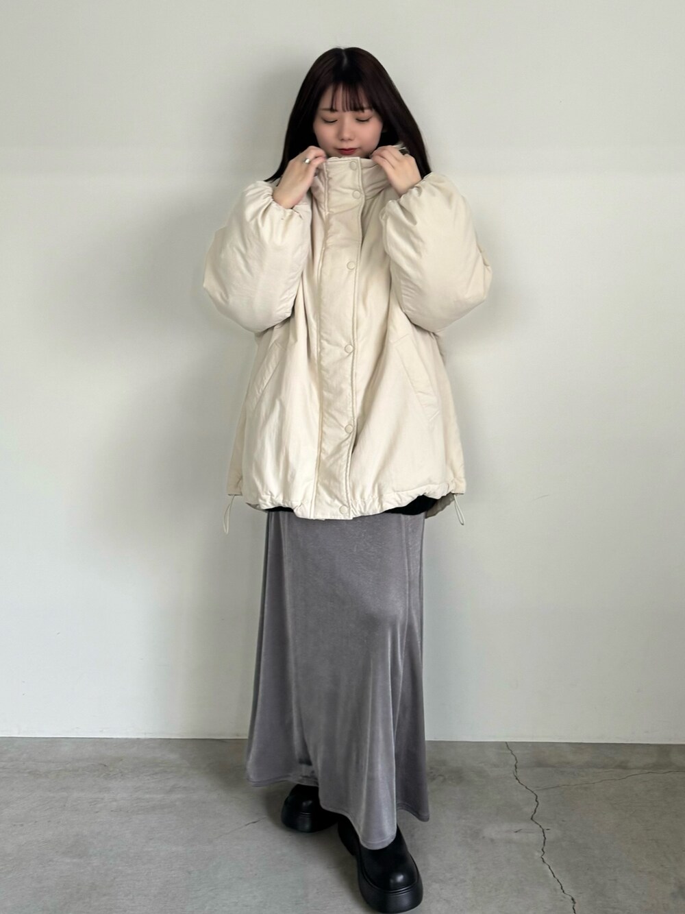ホワイト系のダウンジャケット/コート、グレー系のスカート、ブラック系のブーツを着用したレディースの冬コーディネートの3枚目の写真
