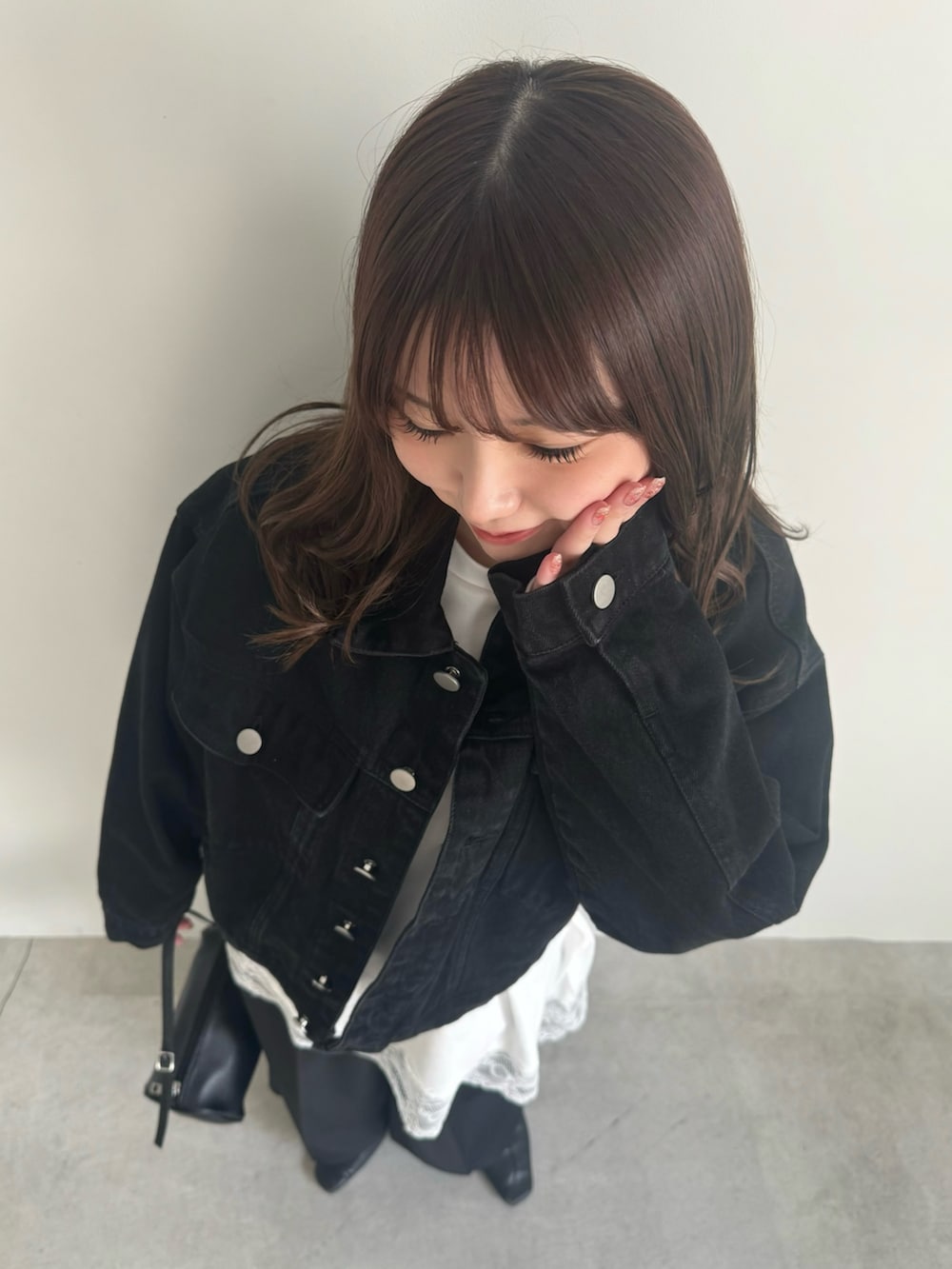 ブラック系のデニムジャケット、ブラック系のスラックスを着用したレディースの冬コーディネートの5枚目の写真