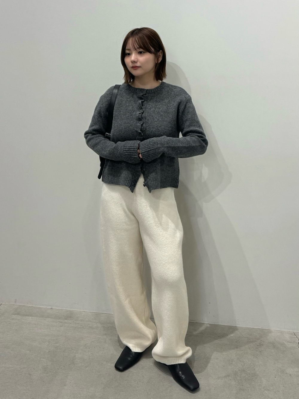 グレー系のカーディガン/ボレロ、ホワイト系のその他パンツ、ブラック系のスリッポンを着用したレディースの秋コーディネートの2枚目の写真