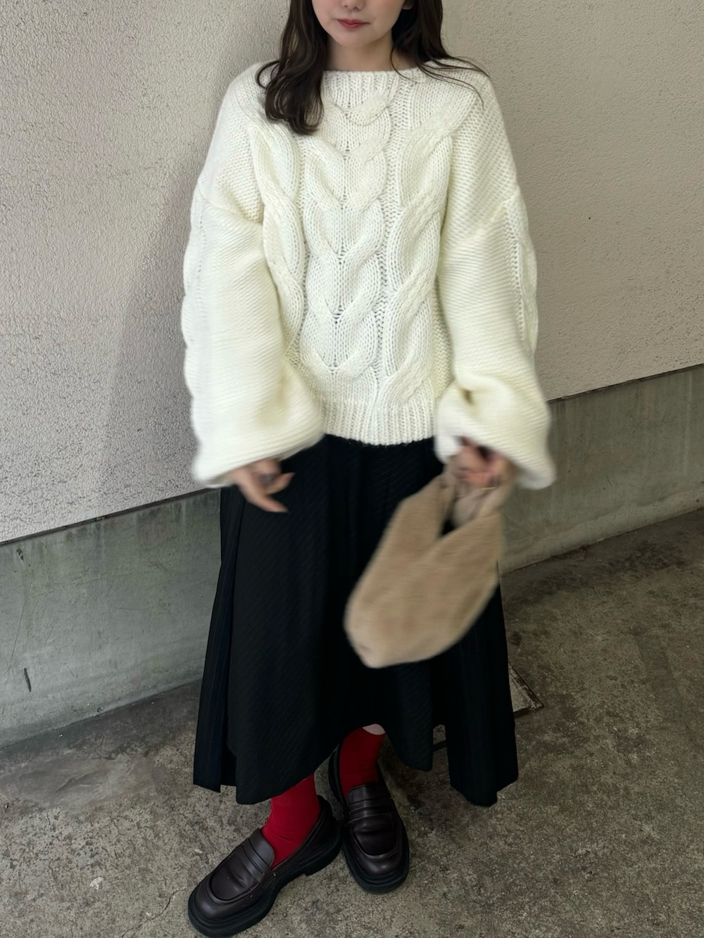 ホワイト系のニット/セーター、ブラック系のスカート、ブラウン系のローファーを着用したレディースの冬コーディネートの3枚目の写真