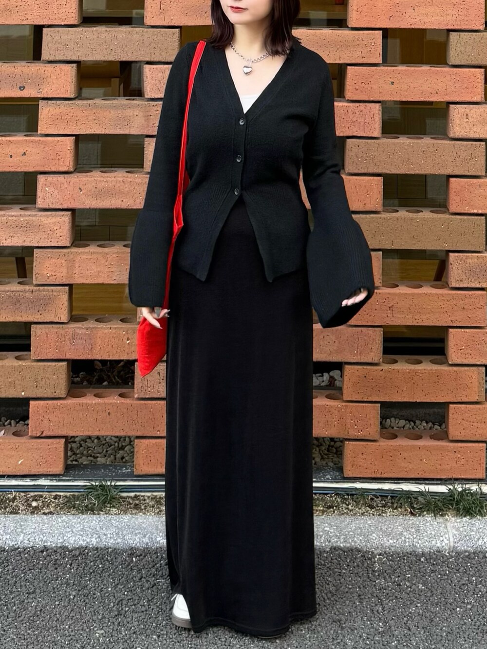 ブラック系のカーディガン/ボレロ、ブラック系のスカートを着用したレディースの冬コーディネートの2枚目の写真