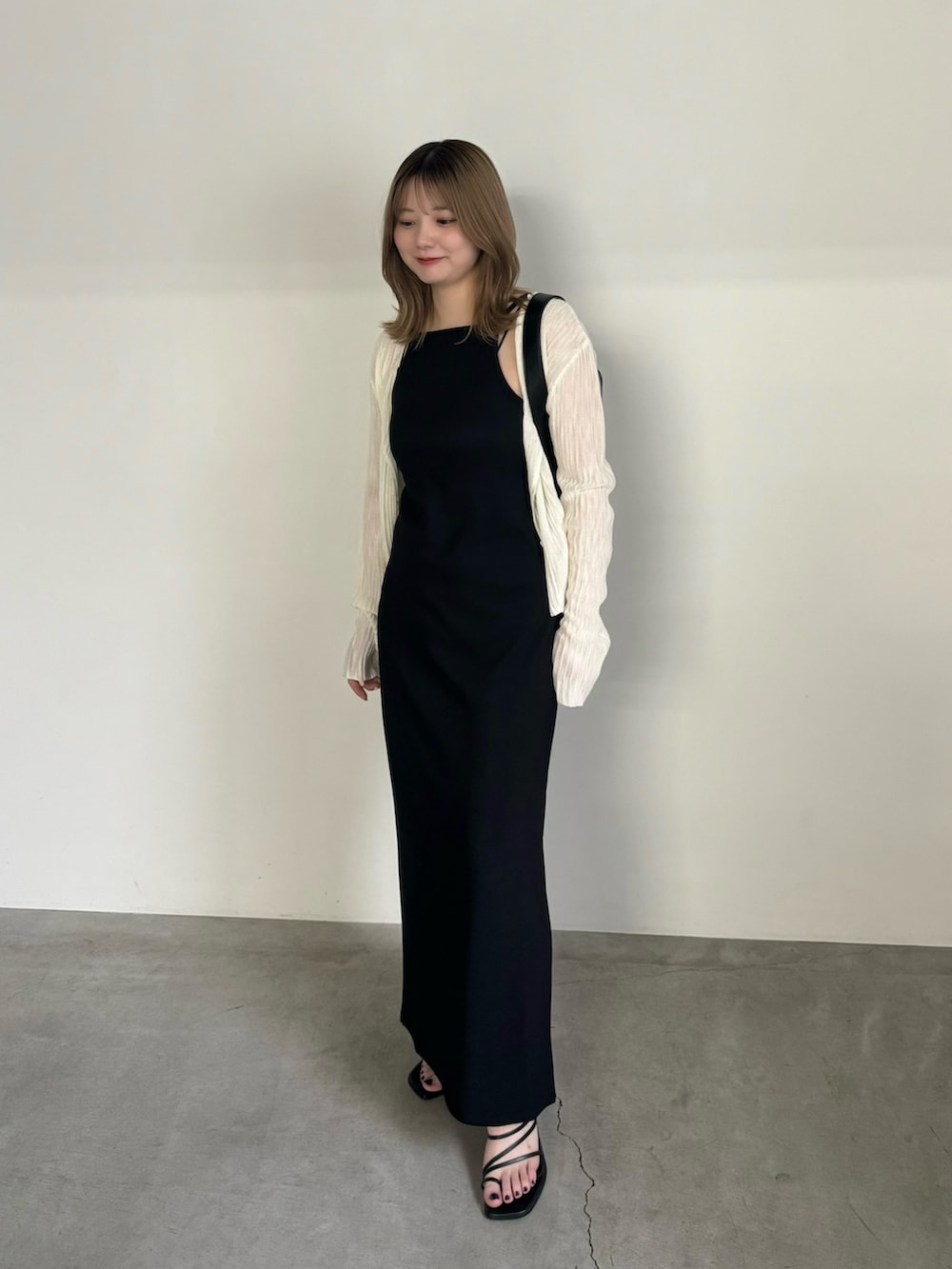 ブラック系のワンピース、ホワイト系のカーディガン/ボレロ、ブラック系のショルダーバッグを着用したレディースの夏コーディネートの2枚目の写真