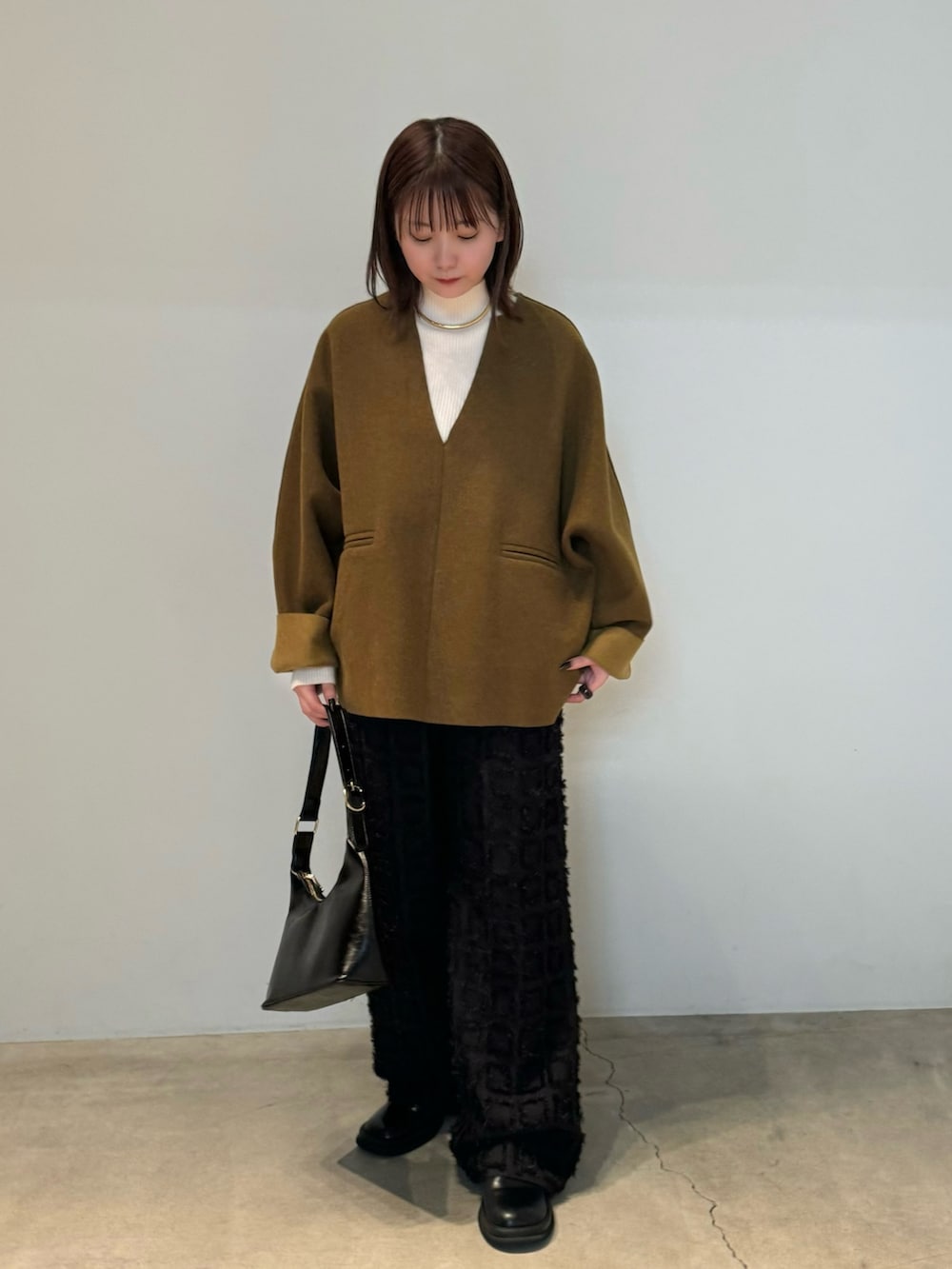 グリーン系のTシャツ/カットソー、ブラック系のその他パンツ、ブラック系のハンドバッグを着用したレディースの秋コーディネートの2枚目の写真