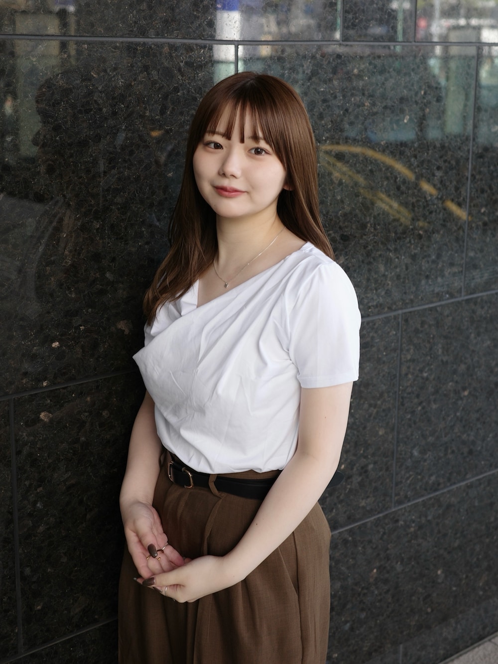 ホワイト系のTシャツ/カットソー、ブラウン系のスラックスを着用したレディースの春コーディネートの3枚目の写真