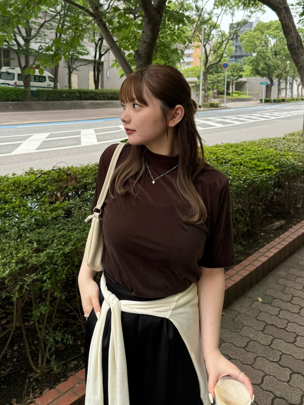 ブラウン系のTシャツ/カットソー、ホワイト系のハンドバッグ、ベージュ系のTシャツ/カットソーを着用したレディースの夏コーディネートの5枚目の写真