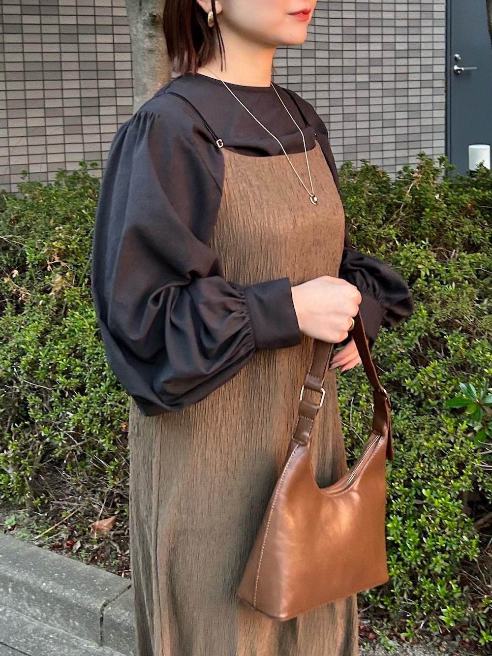 ブラウン系のハンドバッグ、グリーン系のワンピース、ブラック系のシャツ/ブラウスを着用したレディースの夏コーディネートの2枚目の写真