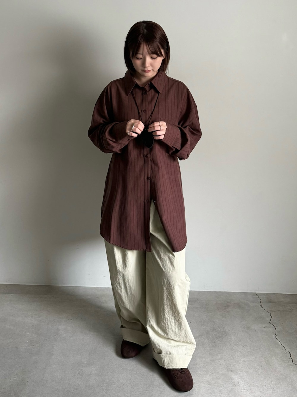 ブラウン系のシャツ/ブラウス、ベージュ系のその他パンツ、ブラック系のショルダーバッグを着用したレディースの夏コーディネートの4枚目の写真