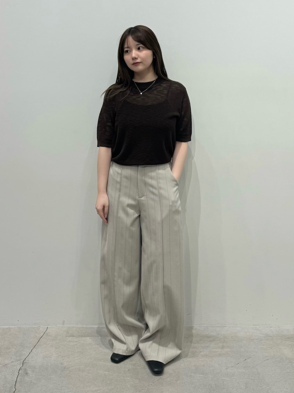 ブラウン系のニット/セーター、グレー系のスラックス、ブラック系のスリッポンを着用したレディースの春コーディネートの4枚目の写真