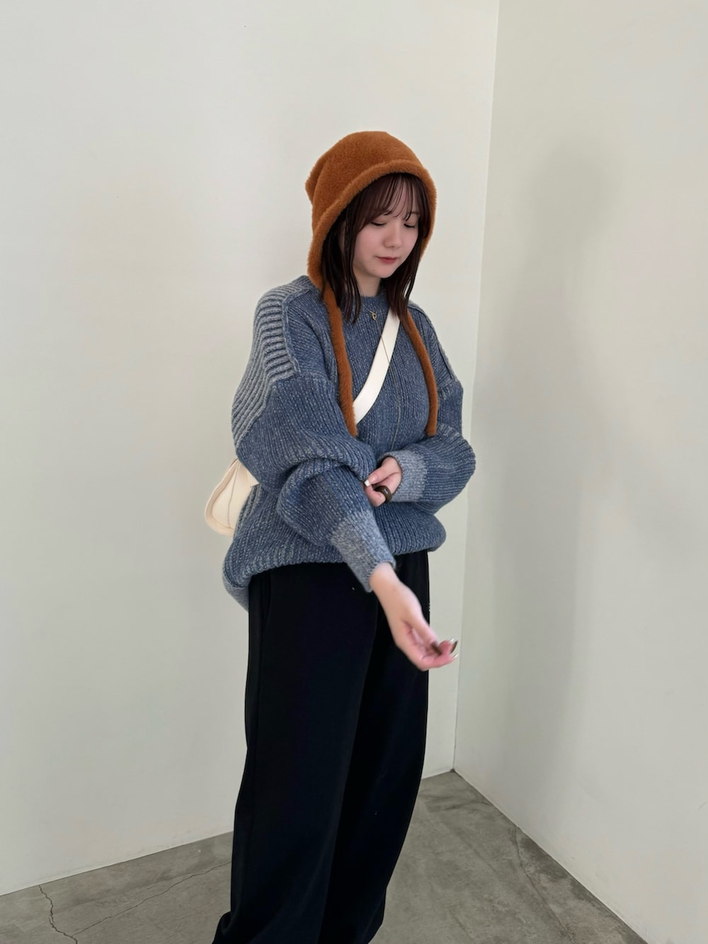 ブラック系のスウェットパンツ、ブルー系のニット/セーター、ホワイト系のショルダーバッグを着用したレディースの秋コーディネートの3枚目の写真