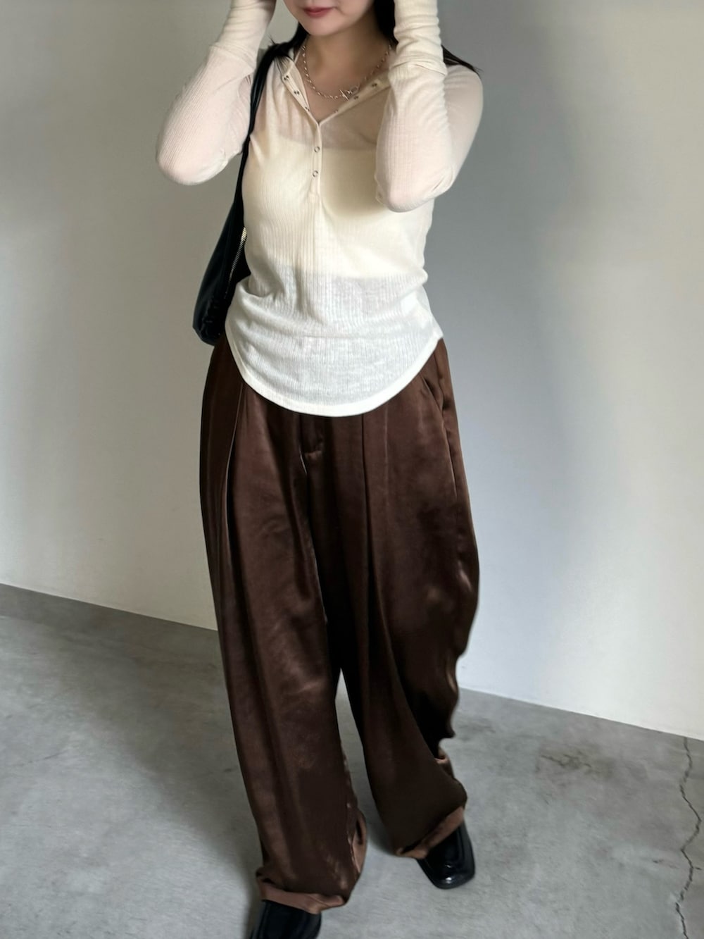 ホワイト系のTシャツ/カットソー、ホワイト系のキャミソール、ブラウン系のスラックスを着用したレディースの夏コーディネートの2枚目の写真